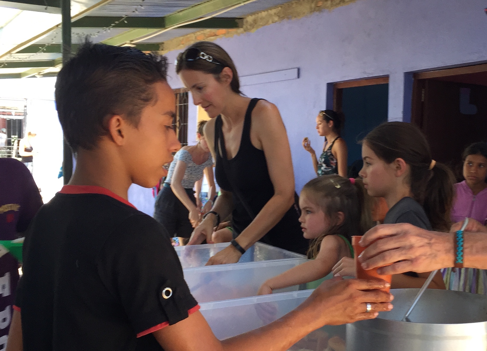 ...get a break from the chaos, a good meal and some homework help (Audrey and kids serving lunch)
